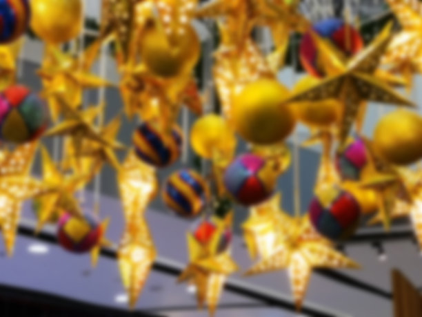 模糊的背景，许多美丽的金色的星星，里面有灯泡和许多彩色的球，从天花板上垂下来。概念装修和复制空间。图片下载