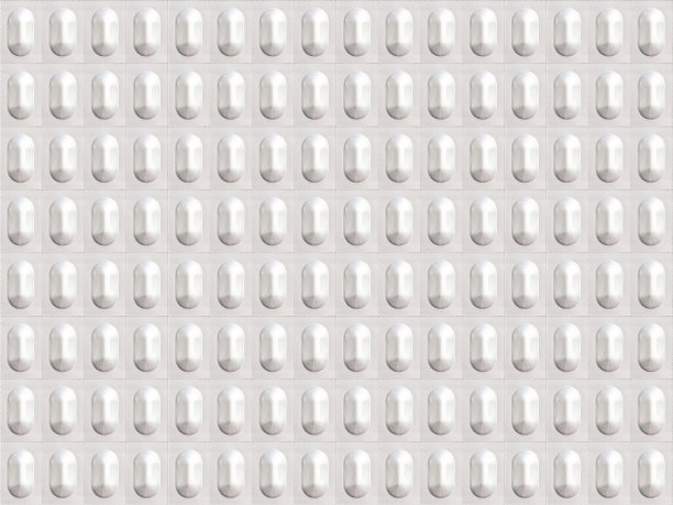 吸塑包装的胶囊，铝背景。医用无缝模式与成堆的药丸在银泡罩包装图片下载