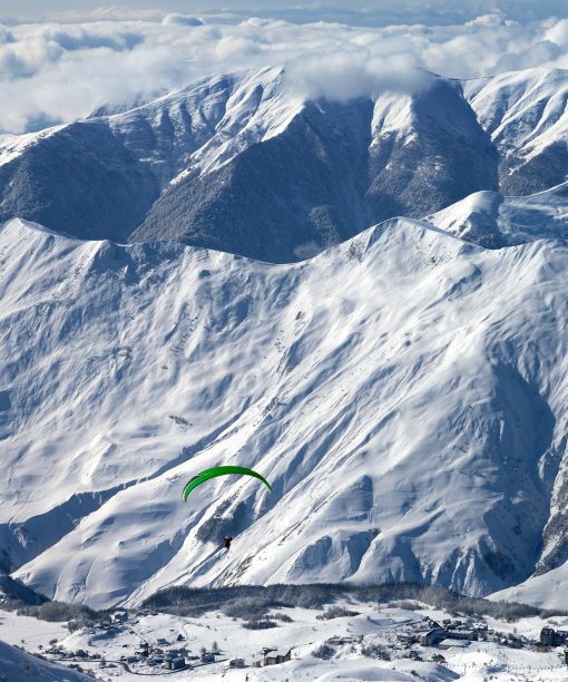 滑雪胜地雪山上的滑翔伞运动图片下载