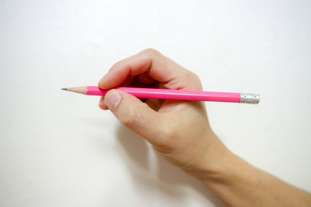 男性的手拿着粉红色的铅笔与绷带在孤立的白色背景图片下载