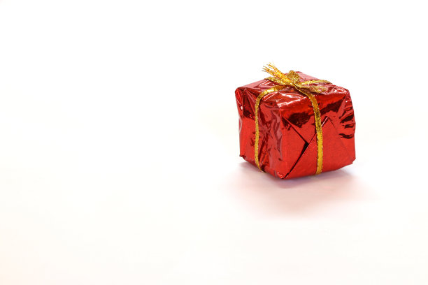 迷你礼盒在红色反映礼物包装与金色绳结孤立在白色背景。图片下载