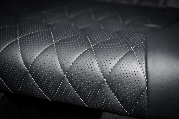 一辆豪华轿车的黑色穿孔皮座椅的一部分图片下载