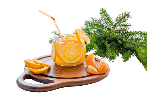 橙子冷饮加冰，柠檬水，橙子片和桔子片放在一个透明的玻璃杯里，在绿色的冷杉树枝的背景下。孤立在白色背景上。图片下载