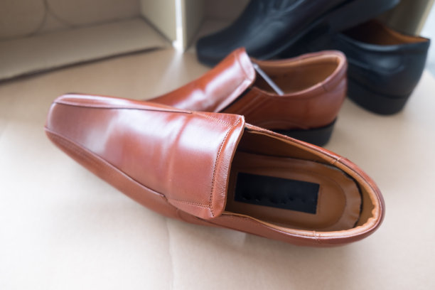 男士的经典棕色皮鞋在棕色背景图片下载