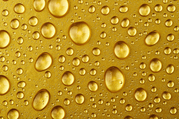 水滴落在金色的背景上图片下载