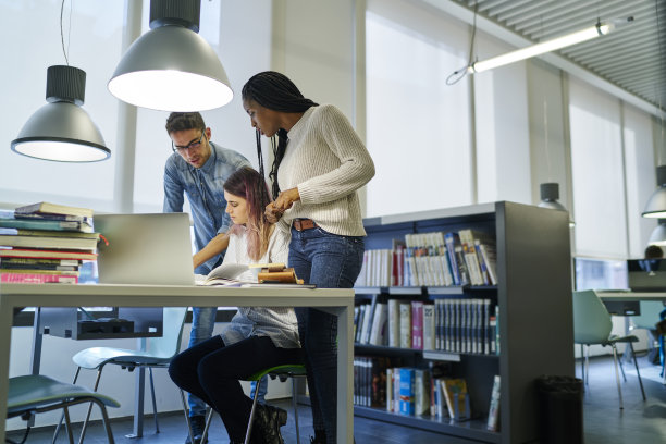 熟练的男女同事一起讨论创业项目的想法和意见，国际学生准备质量控制测试花费时间在大学图书馆素材图片