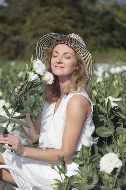 一个年轻女子在花圃里。园丁。图片下载