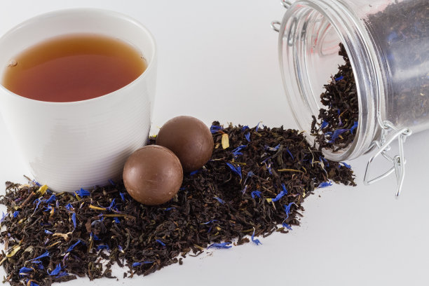 白色背景上的茶杯和茶壶里的茶饼干和新鲜的茶图片下载