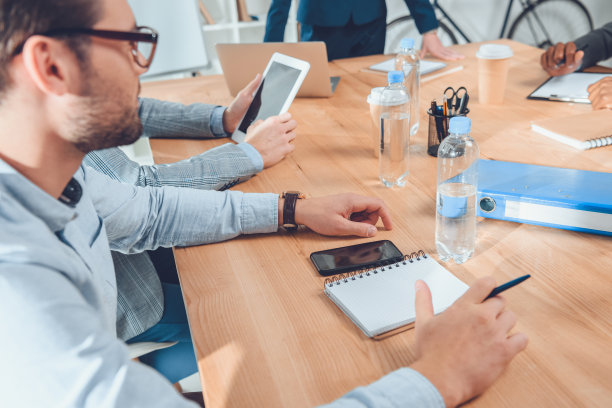 裁剪图像的男人在蓝色衬衫坐在桌子在办公空间图片下载