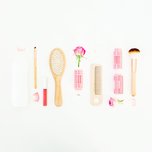 头发造型概念与工具，卷发器和洗发水在白色的背景。美容成分。平躺，俯视图图片下载