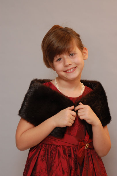 身穿红色连衣裙，肩上披着黑色人造皮草的女孩图片下载