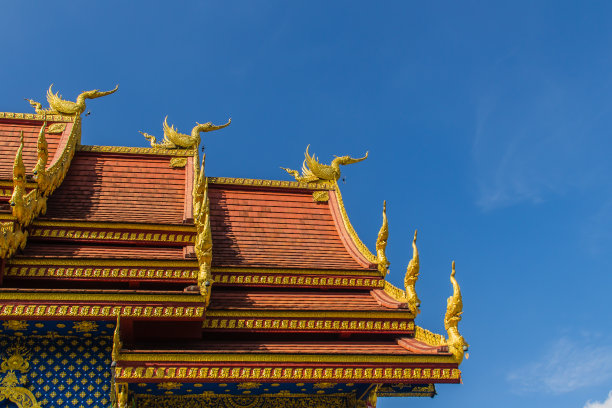 美丽的天鹅和那伽雕塑在蓝色的天空背景下，位于泰国北部清莱省的Wat Rong Suea Ten Temple，也被称为blue Temple图片下载