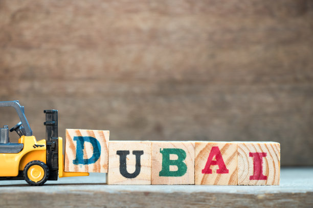 黄色玩具叉车用字母积木拼出“迪拜”图片下载