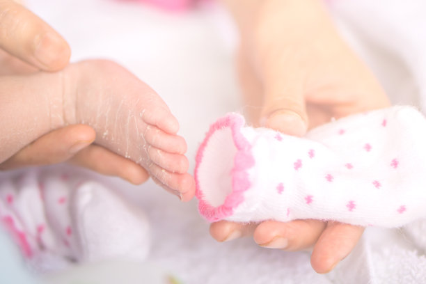 妈妈在冬天给新生婴儿穿袜子图片下载