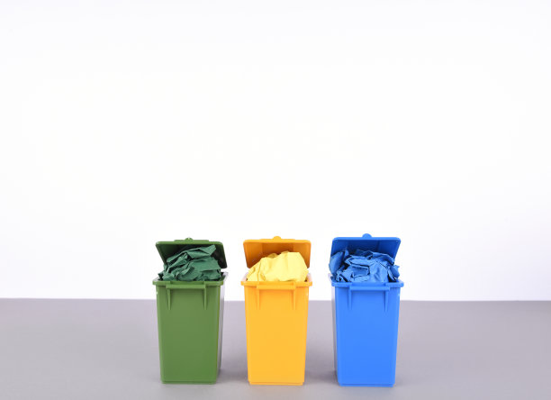 白色背景上的彩色回收箱。素材图片