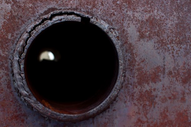 背景与一个生锈的金属表面上的圆形孔图片下载