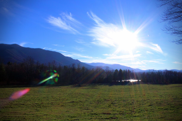 蓝天中阳光的山景照片图片下载