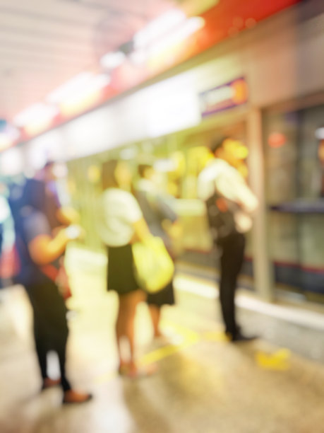 模糊的形象，人们去工作的队伍或排队在高峰时间在早上等待火车地铁站。待在人群中会给日常生活带来压力。运输的概念。图片下载