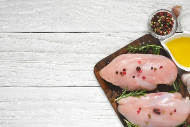 用香料、迷迭香和橄榄油将生鸡柳放在黑石板砧板上图片下载