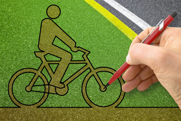 手绘自行车剪影在绿色沥青自行车道-概念形象图片下载