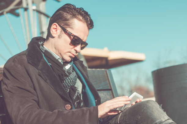 一个中年人正在城市里用触控板看电子邮件。图片下载