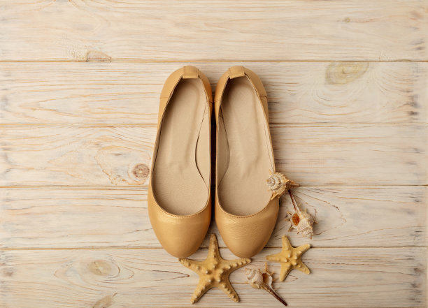 时尚潮流-女鞋的金色珍珠色在木背景上。图片下载