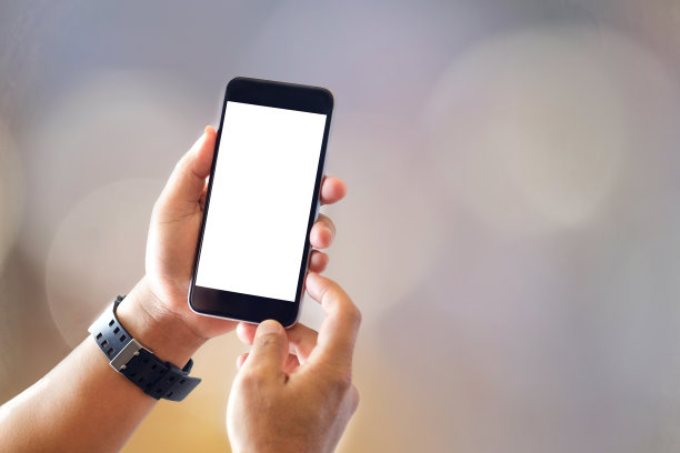 男子与智能手机的特写，背景模糊。通信和技术概念。素材图片