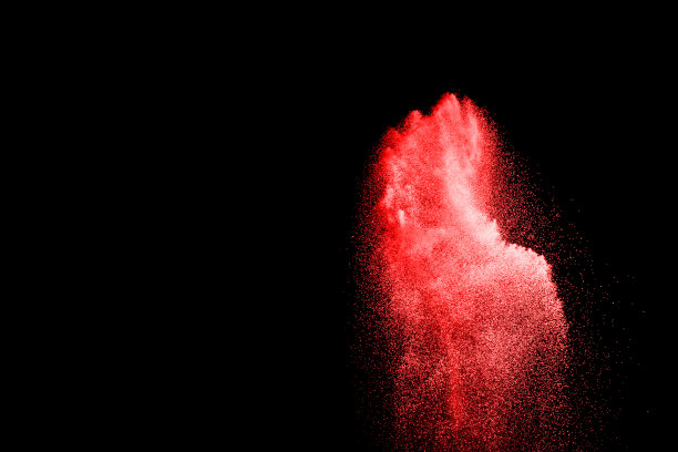 红色粒子在黑色背景上爆炸。图片下载