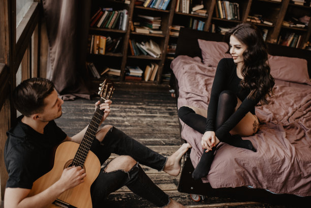 美丽性感的女孩和她的男朋友弹吉他图片下载