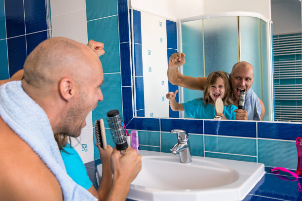 他们唱歌的时候，小女孩从镜子里看着她的父亲。图片下载