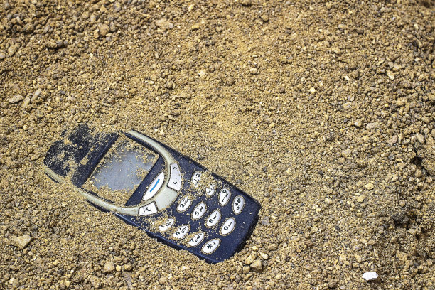 手机埋在灰色的沙子里图片下载