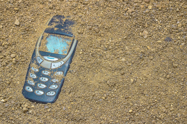 手机埋在灰色的沙子里图片下载