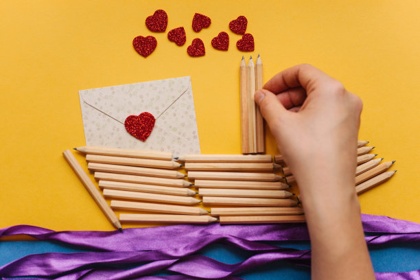 这个女孩用自己的双手制作了一艘铅笔船作为礼物，并发送了一封带有爱心的信。创造性的工作。为假期做准备。图片下载