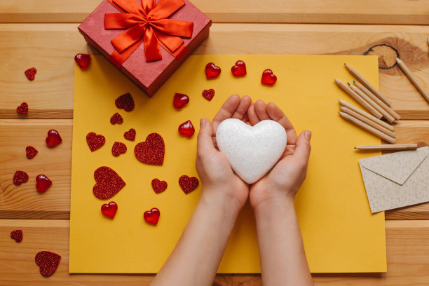 这个女孩手里拿着一个心形的符号，准备把它送给别人。附近有各种象征这一事件的物品。图片下载