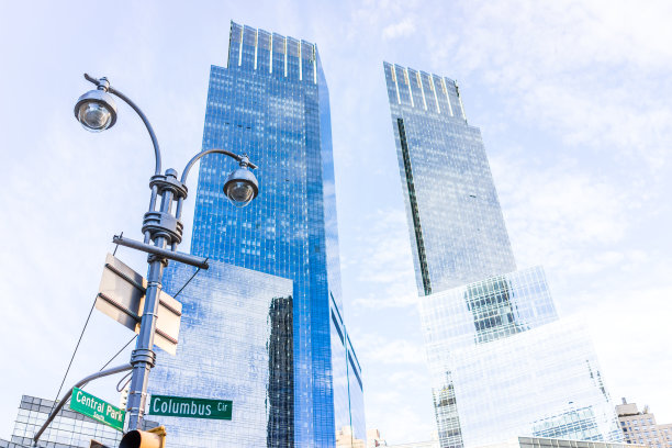 纽约市曼哈顿中城的哥伦布圆环街标志，中央公园南路孤立的天空与玻璃现代摩天大楼特写图片下载