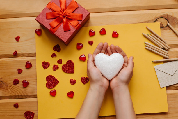 这个女孩手里拿着一个心形的符号，准备把它送给别人。附近有各种象征这一事件的物品。图片下载