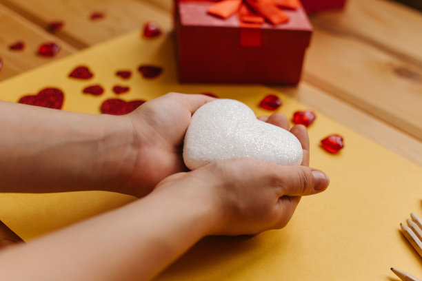 这个女孩手里拿着一个心形的符号，准备把它送给别人。附近有各种象征这一事件的物品。图片下载