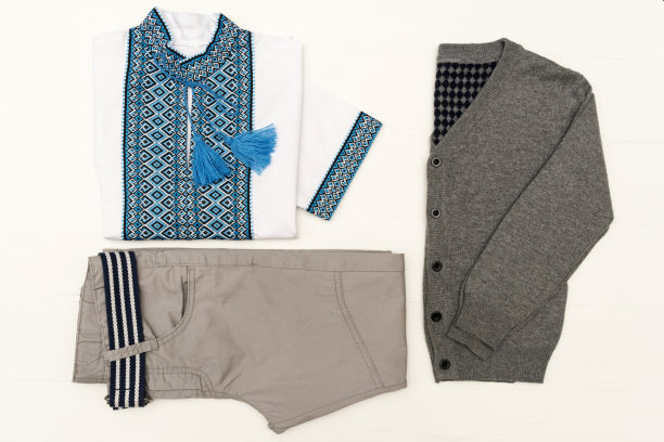 俯视图时尚时尚的样子的孩子的衣服在白色木制的背景。孩子们的时尚。乌克兰传统衬衫图片下载