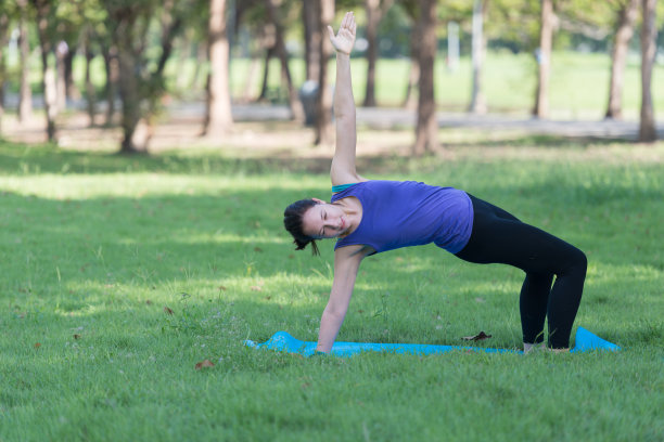 一个年轻女子在公园外面练瑜伽。健康的生活方式和放松的理念。图片下载