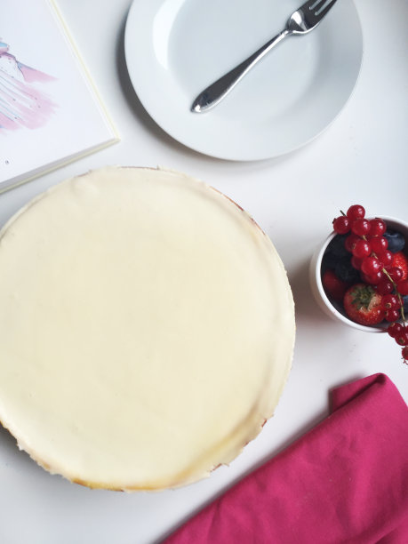 整块芝士蛋糕，浆果，盘子和打开的书图片下载