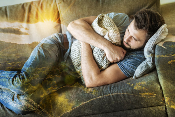 沮丧而疲惫的男人一边看着一边拥抱着枕头图片下载