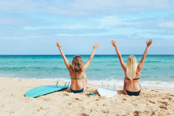 冲浪女孩在海滩上晒太阳图片下载