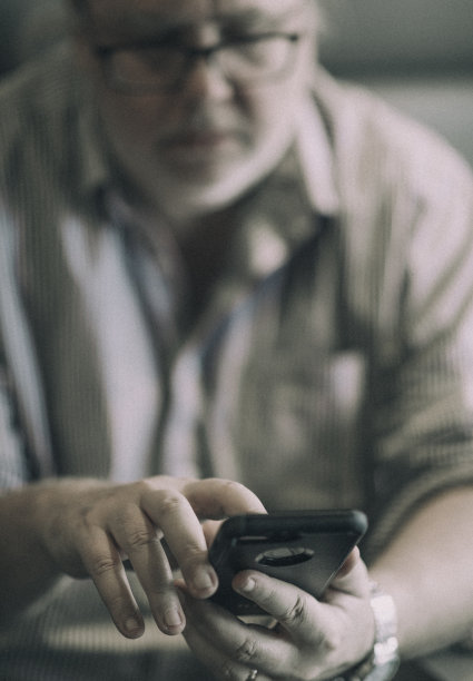 54岁的男人，在用手机查看邮件。图片下载