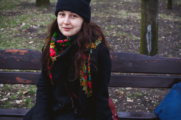 漂亮的年轻女子在俄罗斯围巾坐在长凳上图片下载