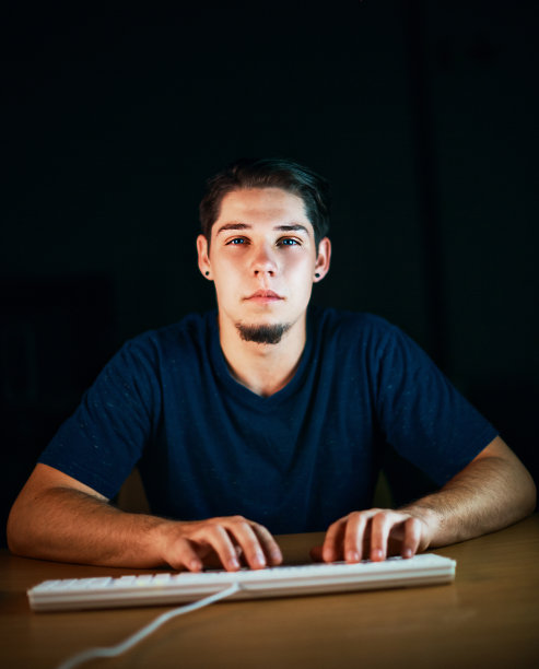 在电脑键盘上打字的年轻人盯着屏幕图片下载