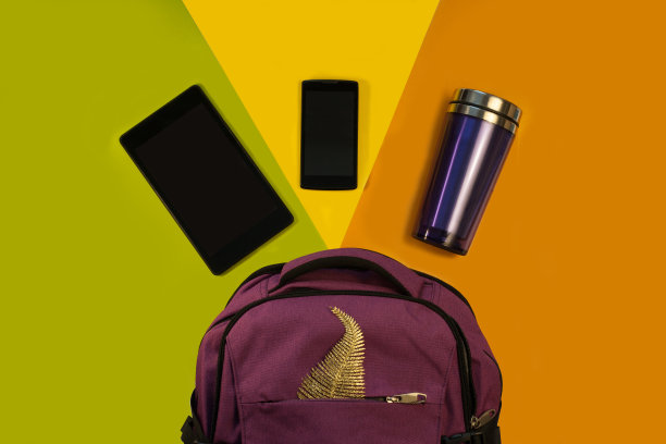 背包的配件，平板电脑，手机和一个热杯在明亮的背景，黄绿橙。学生，青少年，年轻女性的服装图片下载