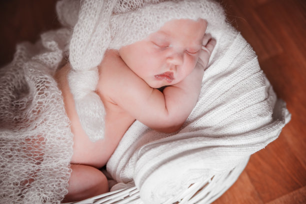 新生儿在柔软的绒毛帽子里睡觉。图片下载