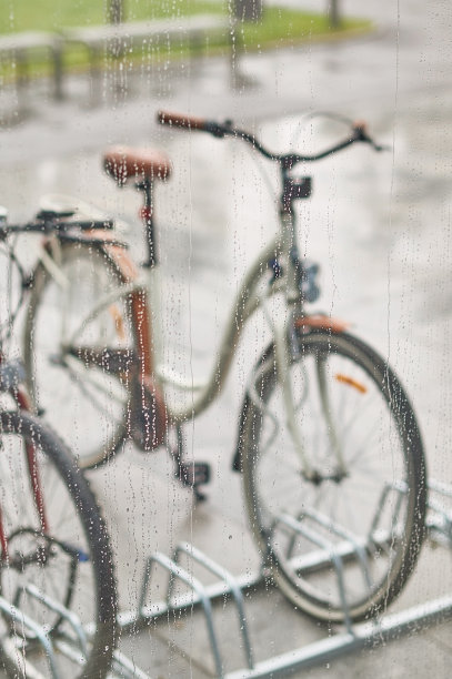 透过带有水滴的玻璃，可以看到停放的自行车图片下载