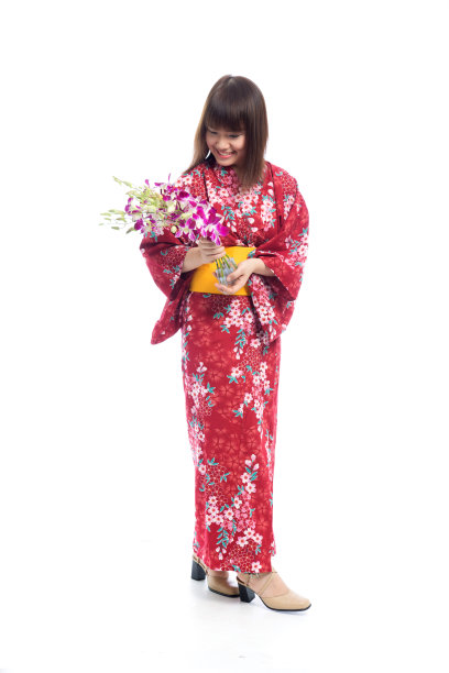 迷人的亚洲女人穿着和服与兰花花在白色的背景。图片下载