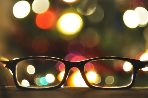 眼镜在一个黑色框架上的特写背景圣诞灯散焦。文本。图片下载